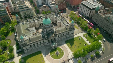 Overhead, left-to-right travelling aerial video of Belfast City Hall in Belfast, Northern Ireland, UK on a bright and sunny day. Filmed in 4K, 60FPS and with Rec709 Color.