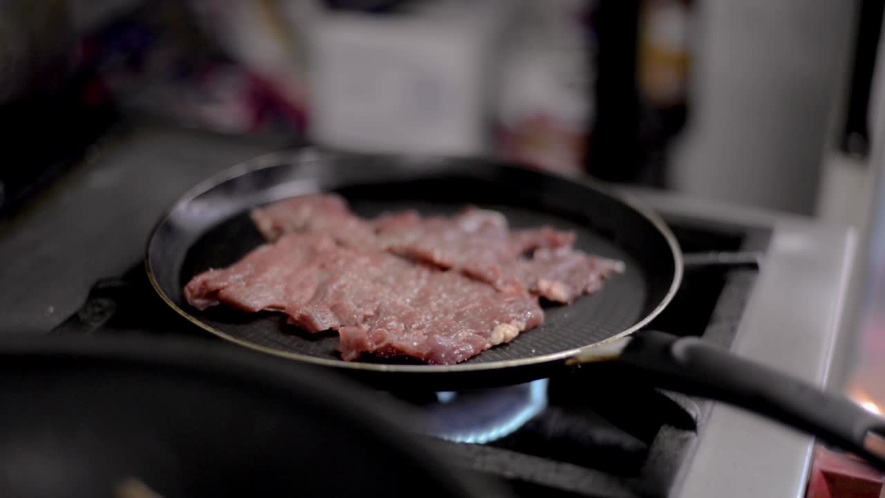 Close up of cooking frying roasting meat steak on a teflon pan at a local diner cafe restaurant in Mexico Latin america