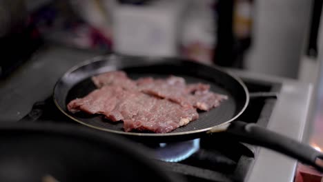 close up of cooking frying roasting meat steak on a teflon pan at a local diner cafe restaurant in mexico latin america