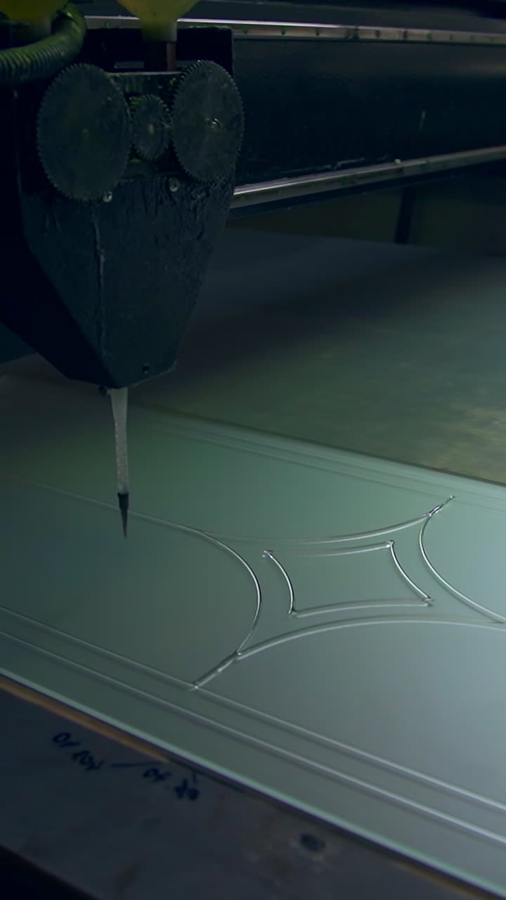 Piece of frosted glass is decorated with lines. Picture is applied on the future door by the automated tool machine. Vertical video