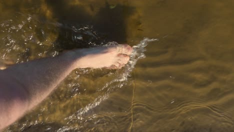 probando aguas marrones poco profundas caminando con los pies descalzos verticales