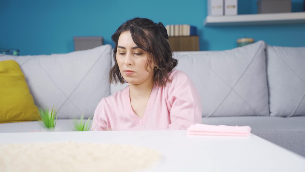 먼지와 더러운 테이블을  ⁇ 고 있는 젊은 여성.