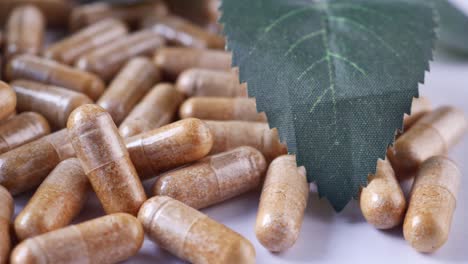 herbal medicine capsule and leaf on white