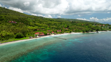 Dock-across-fringing-reef-on-Village-on-Northern-Coast-of-Nusa-Penida-Bali,-aerial