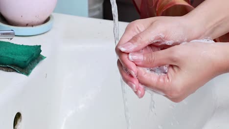 persona lavándose las manos en un fregadero