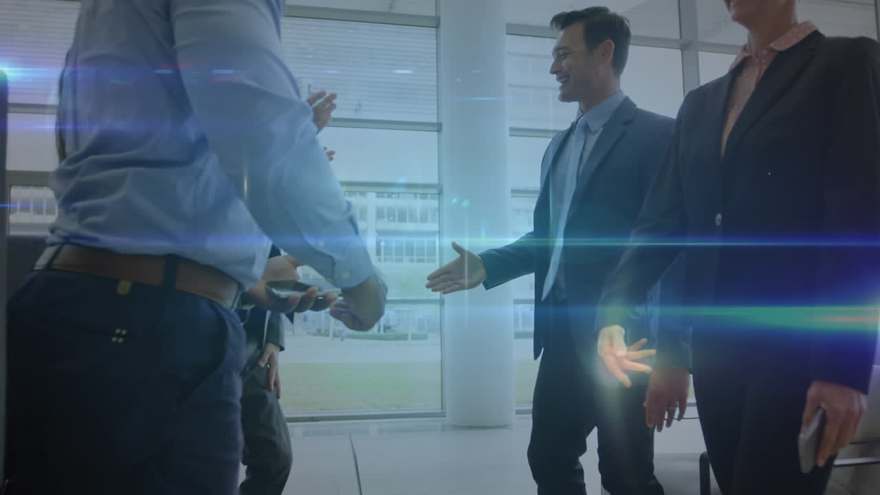 Animazione di una rete di profili e scie luminose su diversi professionisti che si stringono la mano in ufficio