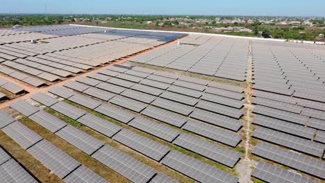 smooth aerial panorama of entire renewable energy solar photovoltaic power plant farm with contrasting dusty panels