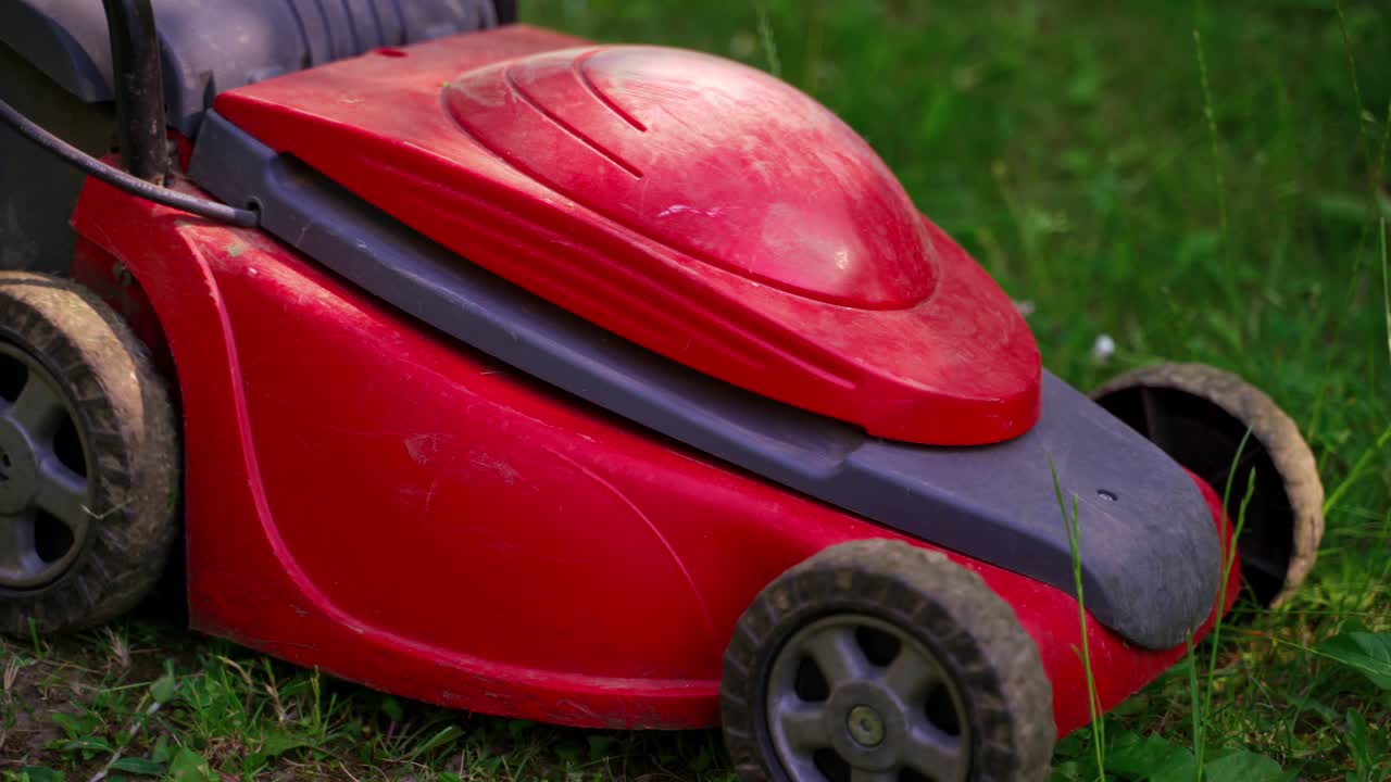 Man using lawn mower outdoor. Lawn mower cutting green grass in backyard