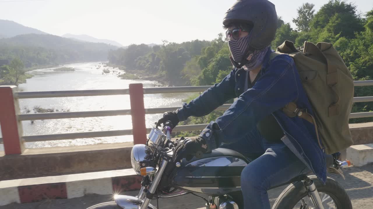 Young Man Riding A Motorcycle On Bridge Cross The River, Video In 4K