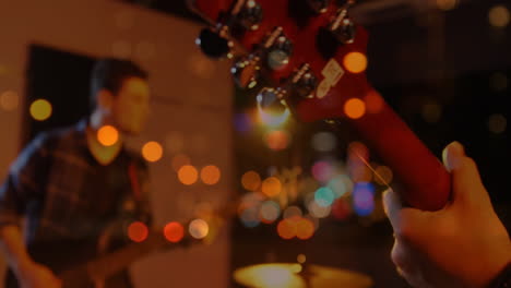 bandmates adjusting red guitar headstock in music studio, adding animated tuning peg icons