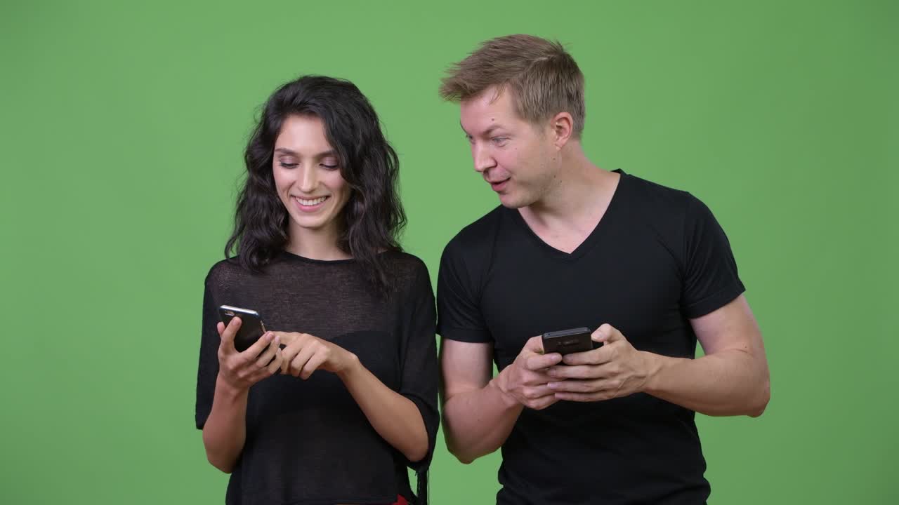 una pareja joven usando el teléfono juntos.