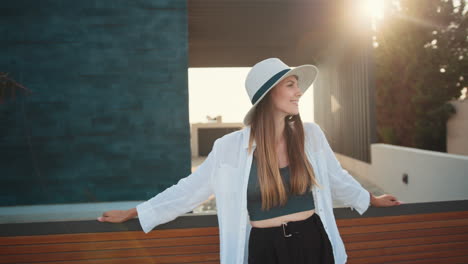 woman in a hat outdoors in front of a modern building