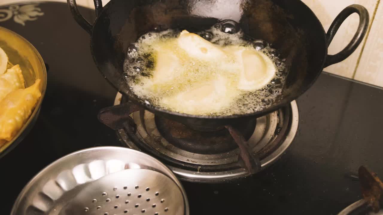 An Indian woman deep frying  gujia, an Indian popular snack especially made in Holi festival of colors