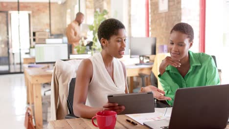 Busy-african-american-colleagues-using-tablet-and-discussing-work-in-office,-slow-motion