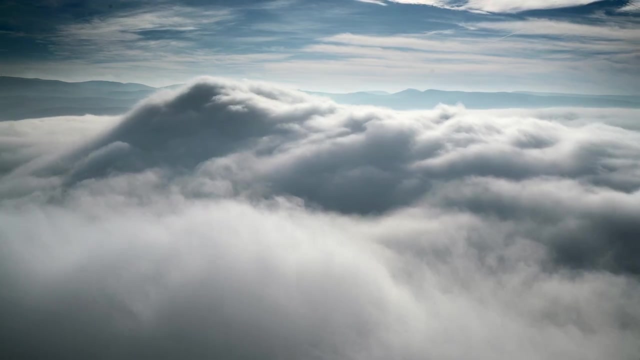 Aerial View of Thick Clouds Over Mountain Range