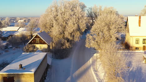 narrow slippery downhill road on sunny winter morning, aerial descending view