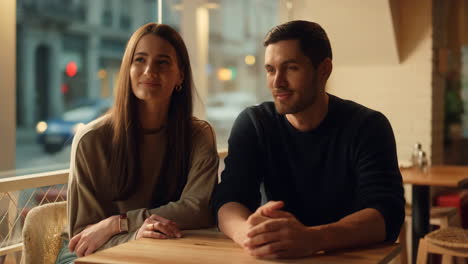 a young couple sitting at a table in a cafe or restaurant