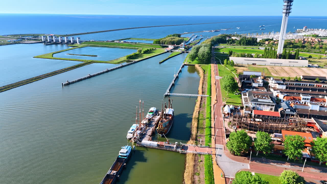 High angle view at the reconstruction of the VOC ship Batavia at Museum Batavialand. Splendid scenery of the waterscape with dikes and sluice. Lelystad, the Netherlands.