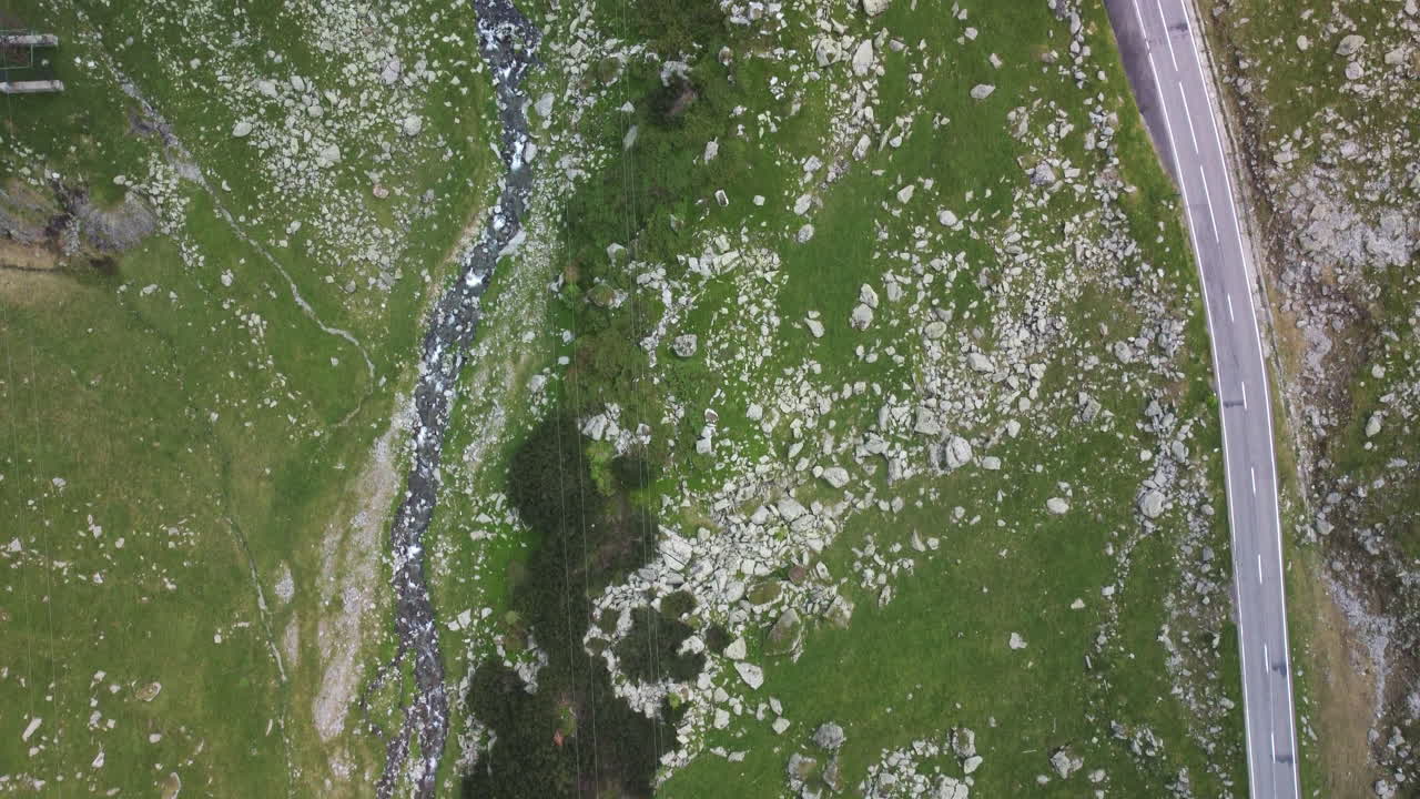 바위 사이의 구불구불한 산악 도로 위의 공중 4k 하향식 드론 샷