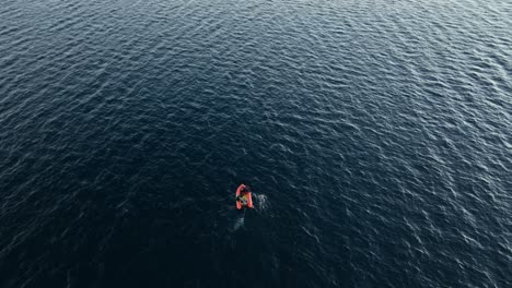 solo swimmer battling across choppy water as the sun comes up. crystal clear waters. athlete. wide drone shot