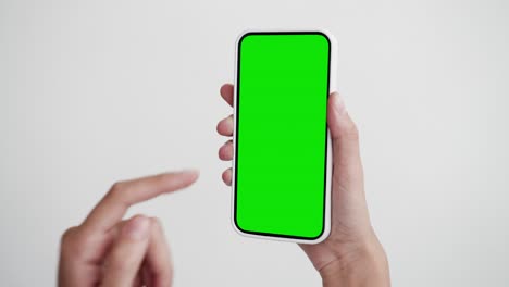 joven usa teléfono inteligente con pantalla verde chroma clave de primer plano. chica sostiene en la mano haciendo clic en el teléfono celular mock-up pov. concepto de reloj mostrar internet redes sociales, llamadas, leer noticias, aplicación, iot, compras electrónicas
