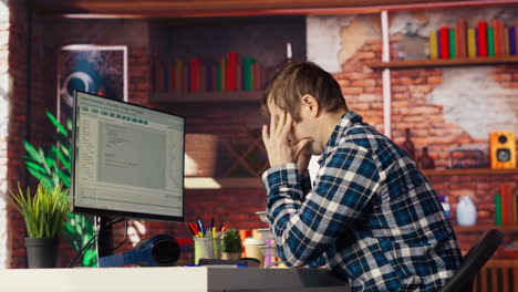 programador en la oficina en casa con fecha límite, enfatizado para terminar de depurar el software