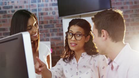 businesswoman interacting with coworkers while working on computer