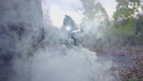 a black police officer appears through thick smoke around the corner with his gun drawn