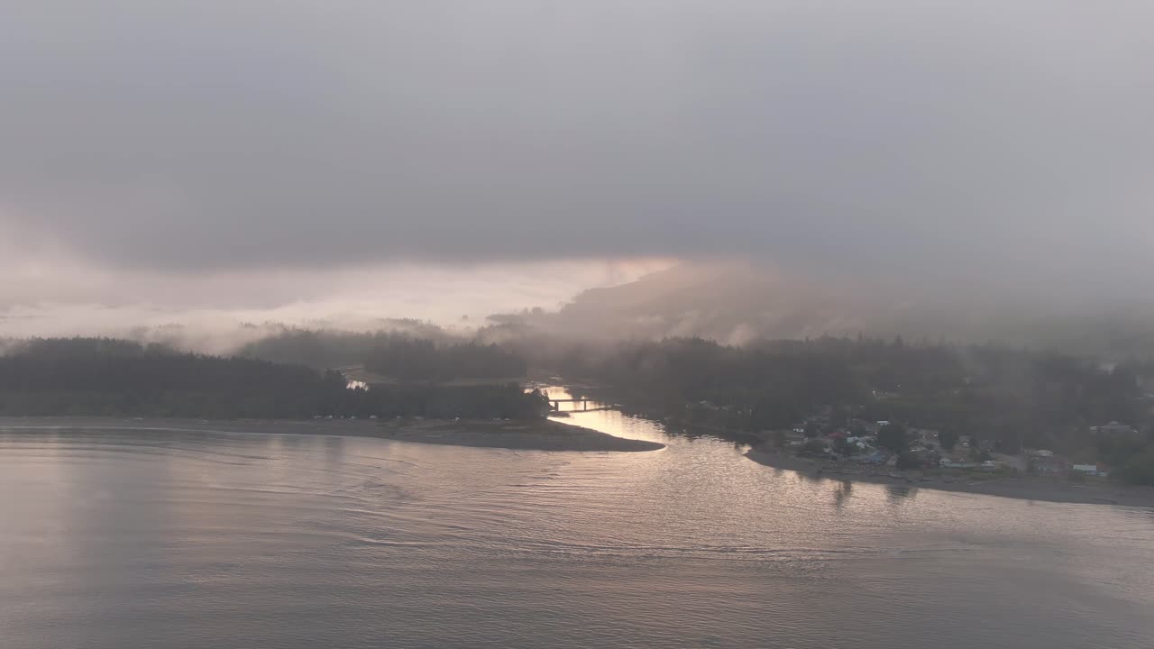 흐린 여름 일출 동안 태평양 해안에 있는 작은 외딴 마을의 공중 전망