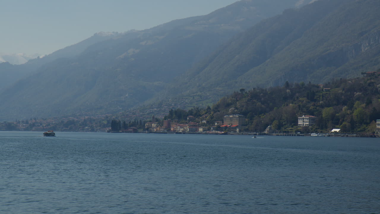 el lago de como con las montañas nebulosas a la vista en bellagio, lombardía, italia