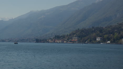 el lago de como con las montañas nebulosas a la vista en bellagio, lombardía, italia