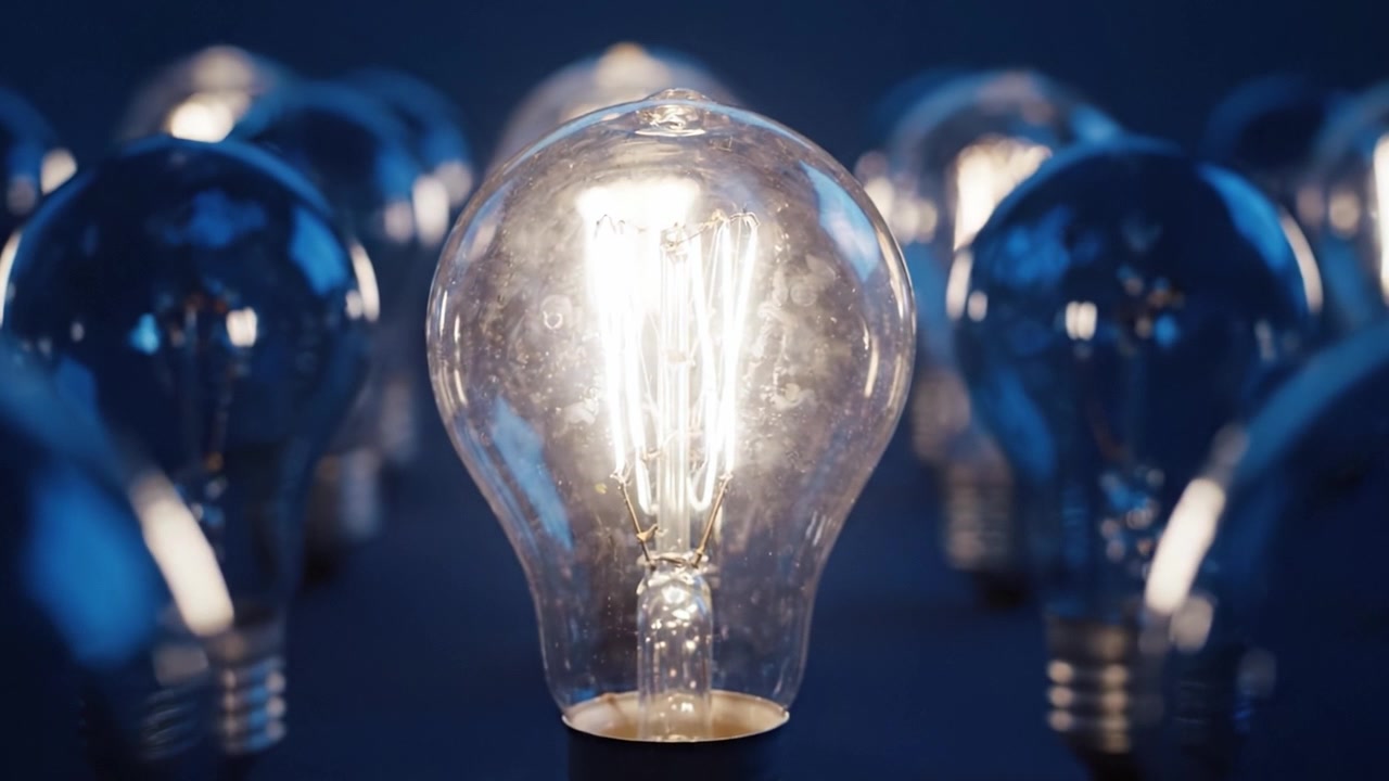 Primo piano accattivante di una lampadina illuminata su sfondo scuro, che mostra l'arte e la tecnologia dell'illuminazione con un focus su elementi di design vintage.
