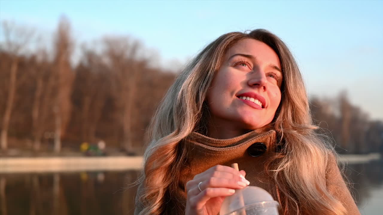 Smiling young woman drink coffee with a bamboo straw