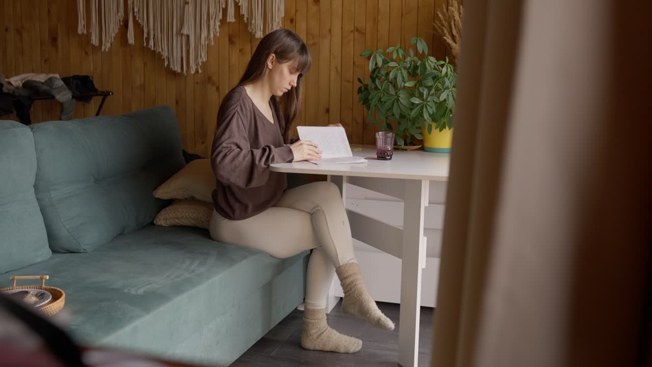 Woman Writing at Table on Couch
