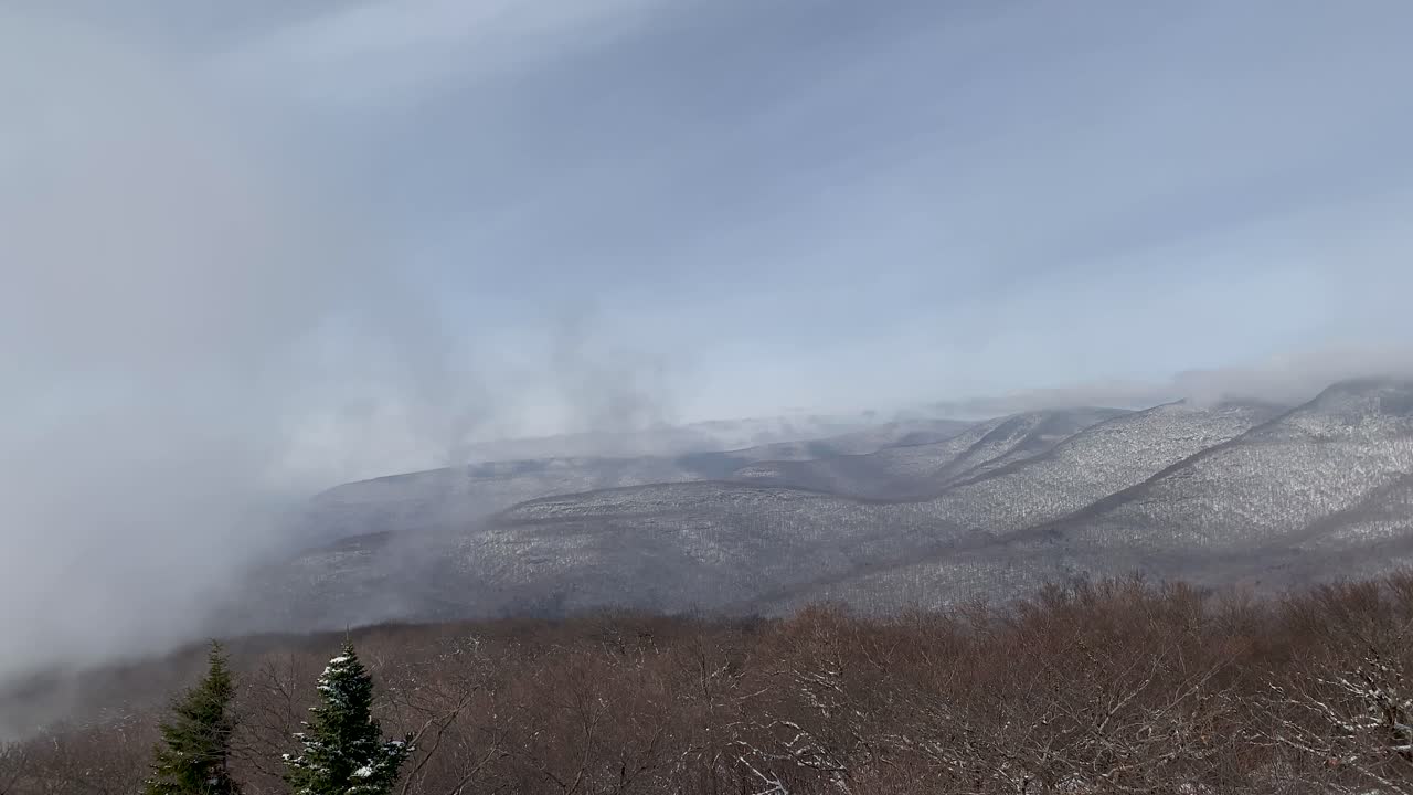 Low-lying clouds blowing over the Catskill Mountains in winter as seen from Overlook Mountain in Woodstock.