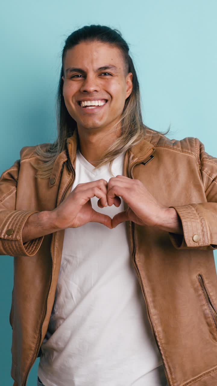 Joven lanzando un beso y haciendo un gesto de corazón