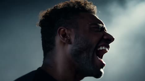 profile close-up of a man screaming or shouting with intense emotion