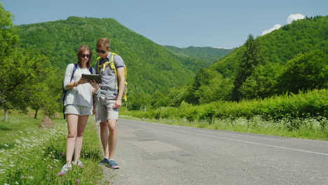 tourists are guided by the terrain enjoy the tablet they stand in a picturesque place amidst the mou