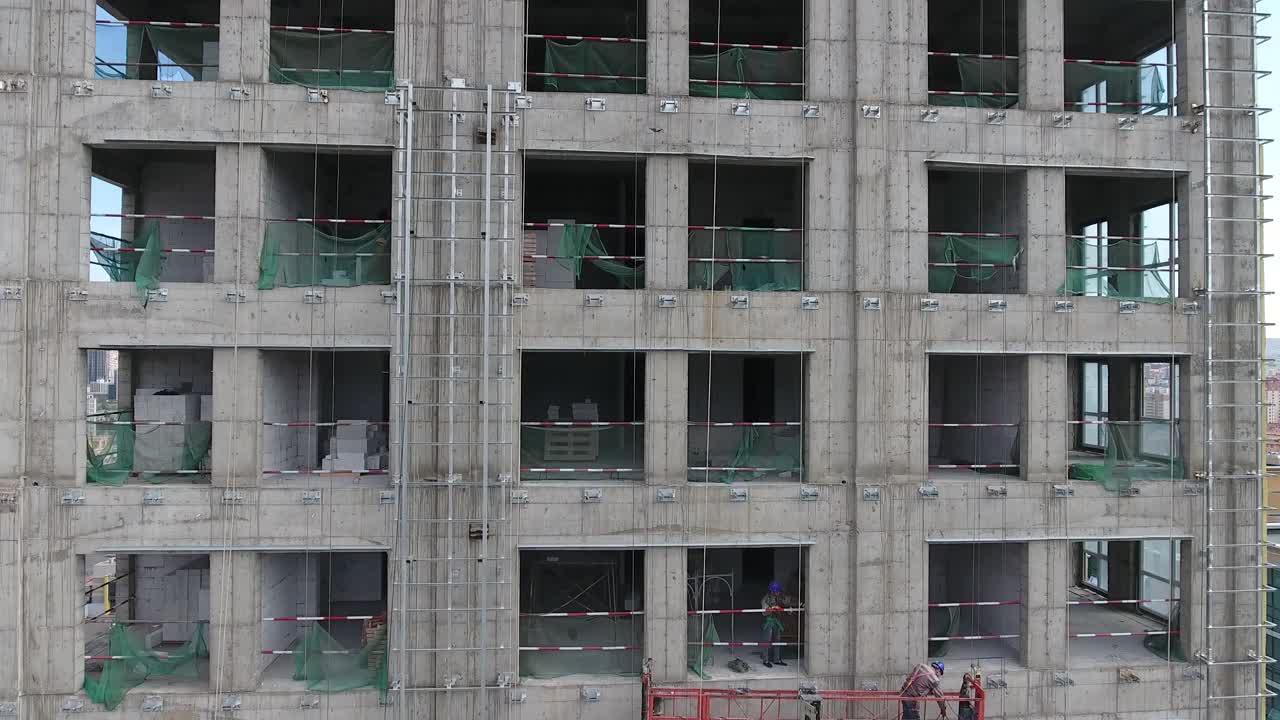 trabajadores en un edificio en la construcción drone aéreo disparado subiendo y descubriendo