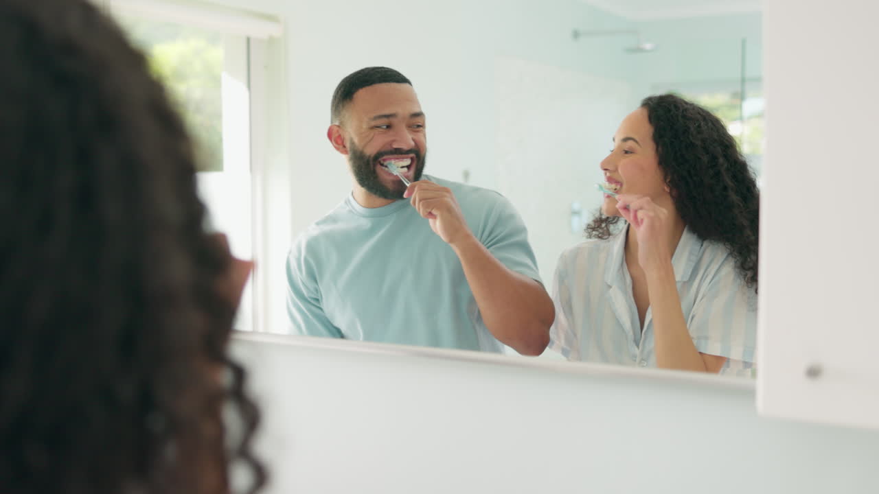 African couple, brushing teeth in mirror together