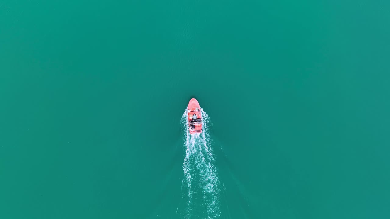 lancha motora de seguimiento a vista de pájaro deslizándose a través del agua verde