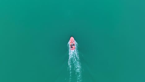 birdseye view tracking motorboat gliding through green water