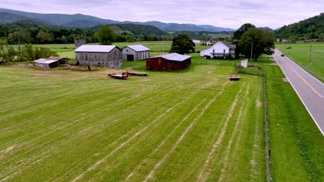 car travels down long roadway aerial with farmstead in background aerial near mountain city tennessee