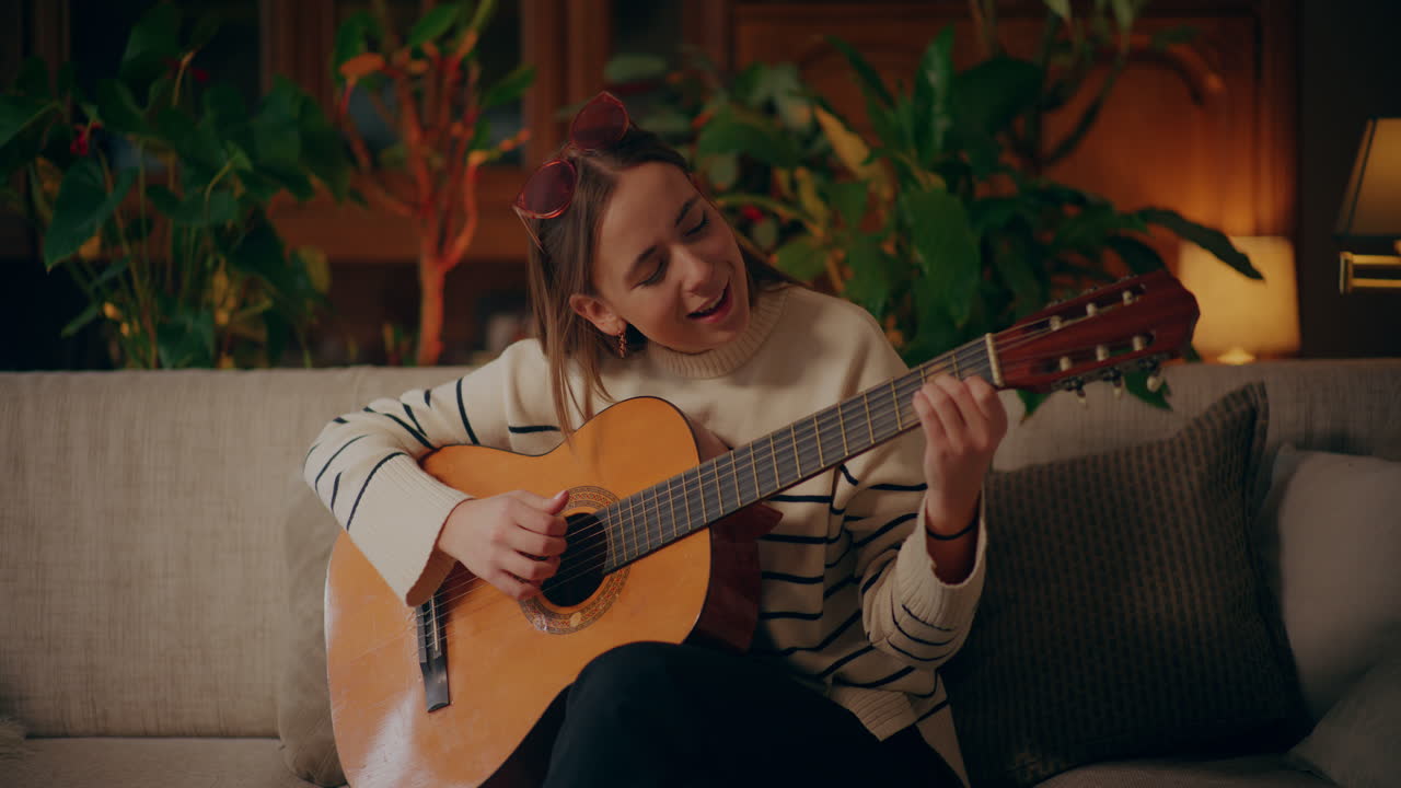 Kvinna spelar gitarr, skriver låt, komponerar musik
