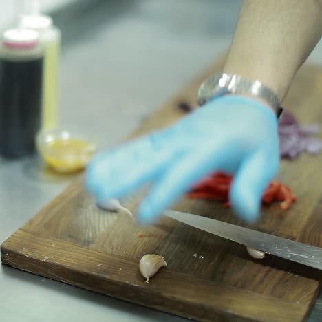 hand cutting the onion and garlic in the kitchen