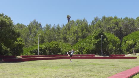 a beginner doing a yoga position in a grass field