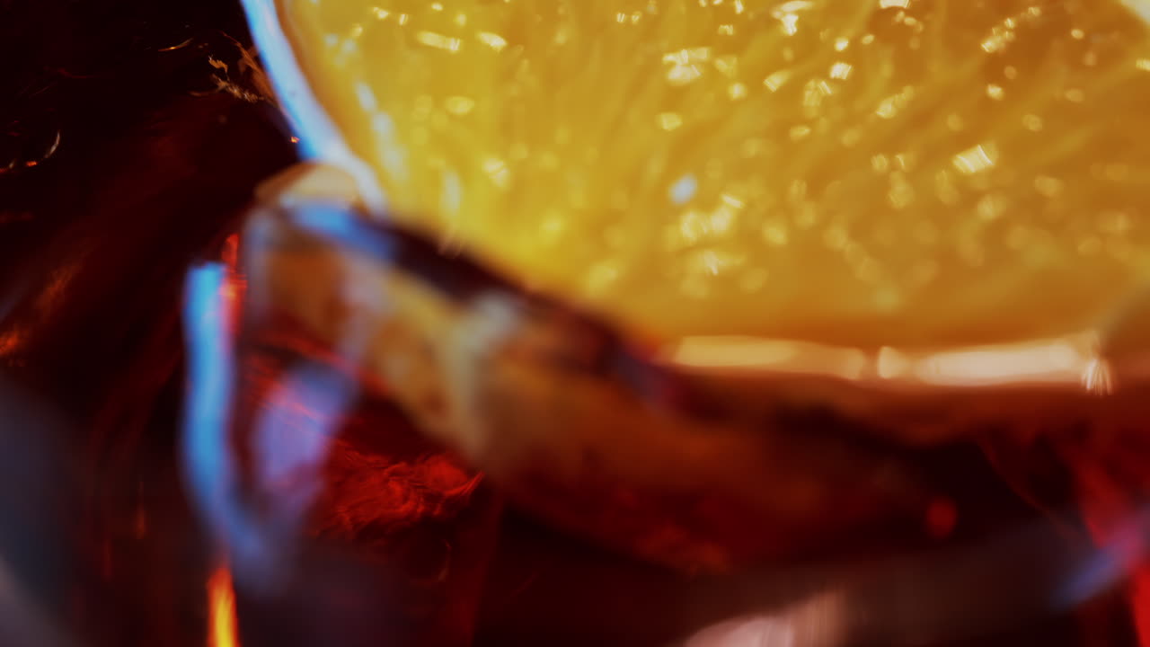Primo piano di un cocktail Negroni con fetta d'arancia e cubetti di ghiaccio su un tavolo di legno