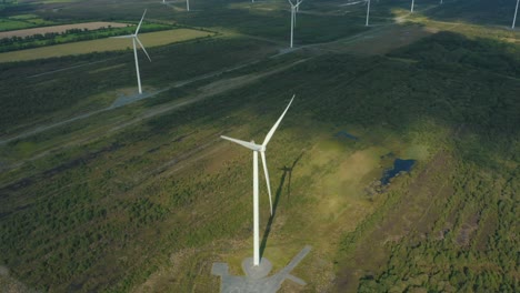 Beautiful-cinematic-descending-tilt-shot,-wind-farm-comes-into-frame,-aerial-view,-4K