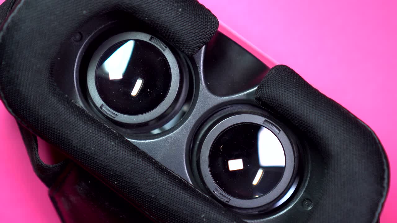 máscara de realidad virtual girando sobre un fondo rosado giratorio.