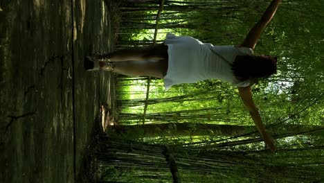 Slow-motion-dolly-shot-of-a-young-woman-in-white-dress-walking-through-an-avenue-of-plants-in-bali-indonesia